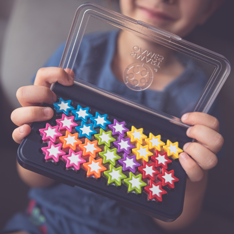 dziecko prezentuje komplet ułożonych gwiazdek w pudełku gry IQ Stars Smart Games
