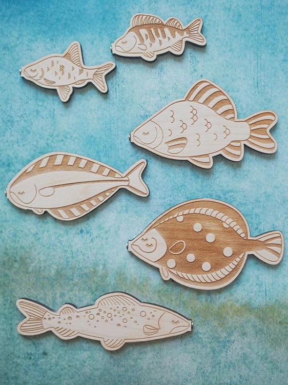 Drewniane rybki edukacyjne na tle niebieskim – gra Stuka Puka