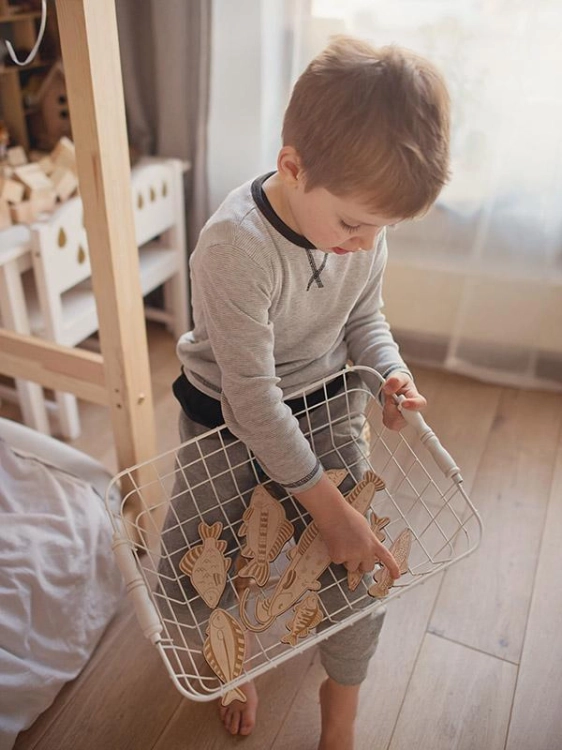 Dziecko trzyma koszyk z elementami gry zręcznościowej Stuka Puka