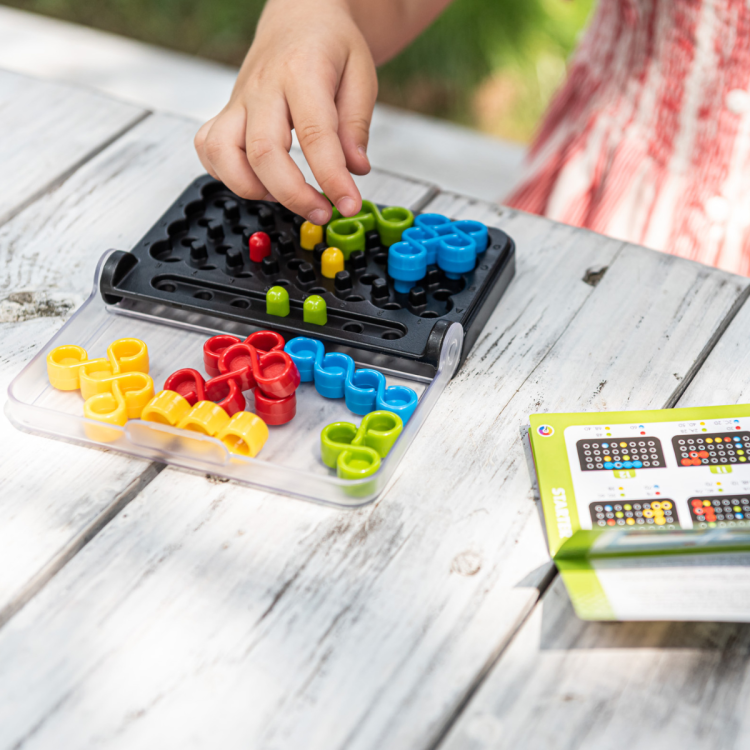 ręka dziecka grająca w iq twist na stole na zewnątrz