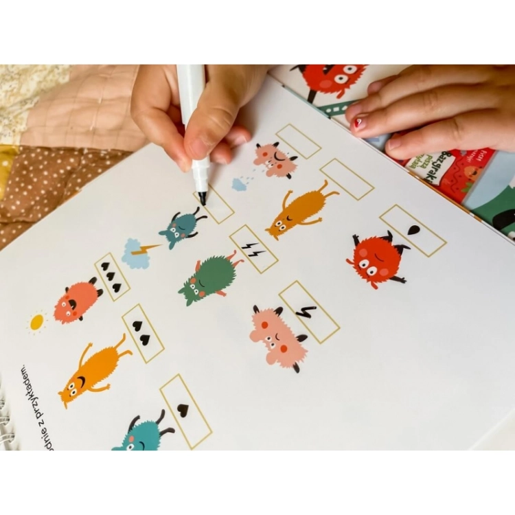 Dziecko koduje wzory w książeczce edukacyjnej Bazgraki kodują