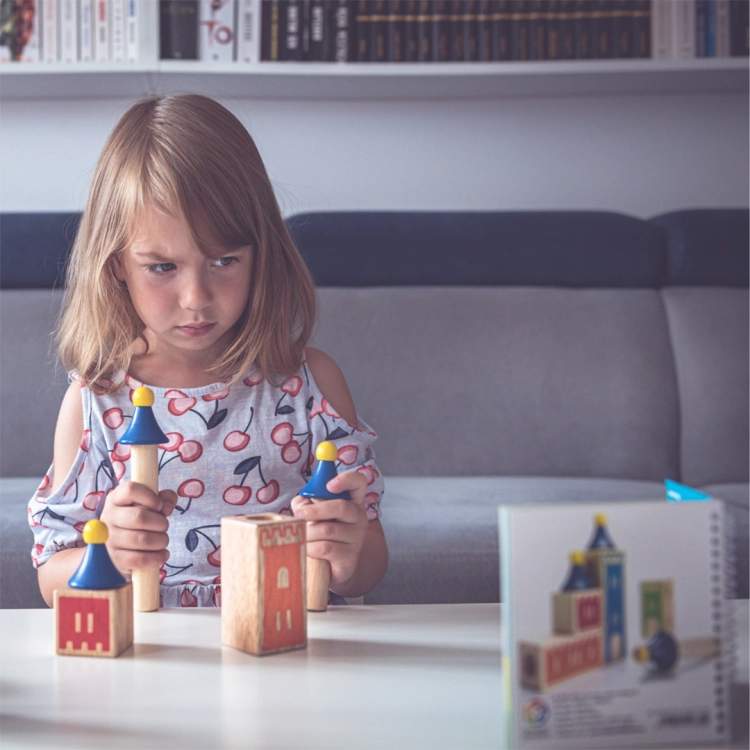 dziecko z grą Mądry Zamek – kolorowe drewniane elementy logiczne