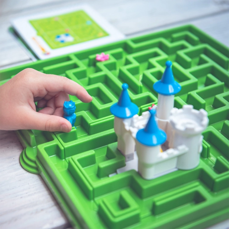 Ręka dziecka przesuwa figurkę księcia po labiryncie w grze Śpiąca Królewna