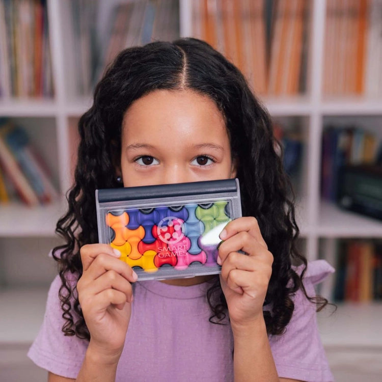 Dziewczynka trzymająca układankę IQ Waves Smart Games przed sobą