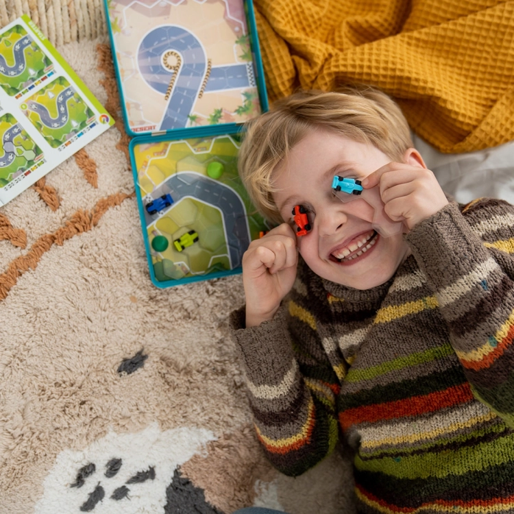 Dziecko bawi się samochodzikami z gry Wyścigłówki Smart Games