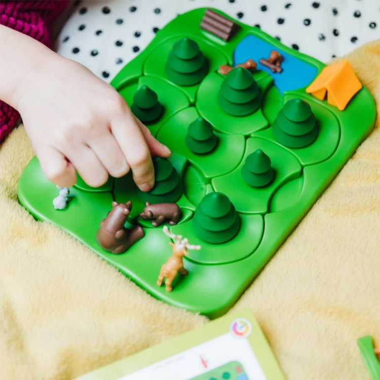 Plansza gry Misie w lesie – ręka dziecka przesuwa drzewko