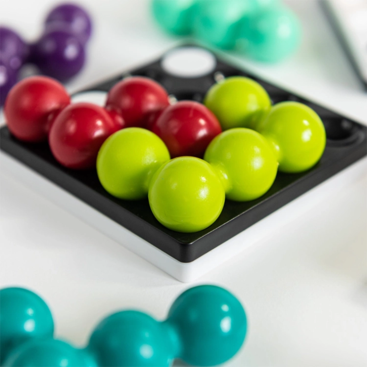 Zbliżenie na czerwono-zielone elementy układanki Kwadrylion na czarnej planszy