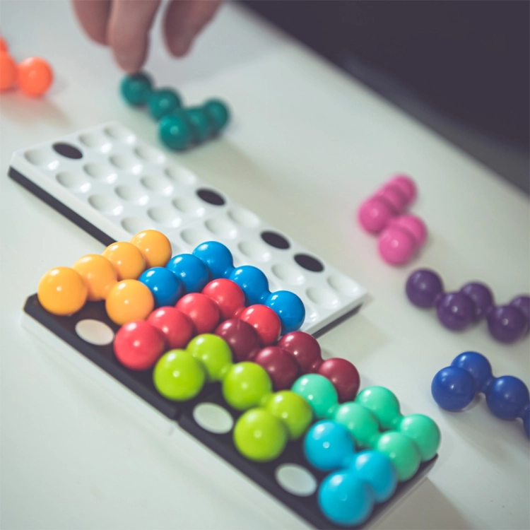 Plansze gry Kwadrylion wypełnione kolorowymi kulkami podczas układania