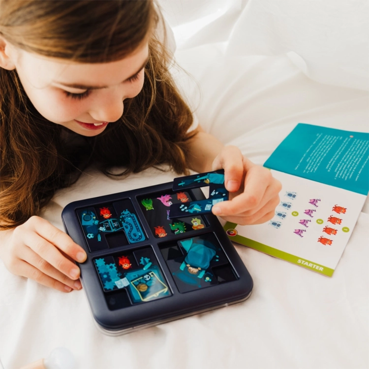 dziewczynka układająca kafelek na planszy gry Potwory – Zabawa w Chowanego