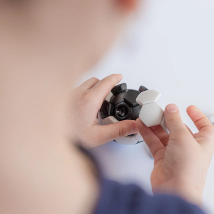 Dziecko układa elementy łamigłówki Plug & Play Ball