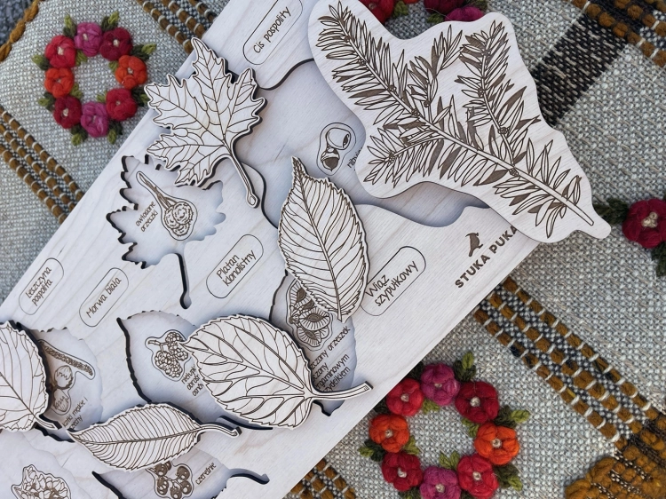 Drewniane puzzle Sounds Wood z liśćmi i nasionami drzew na tle tkaniny