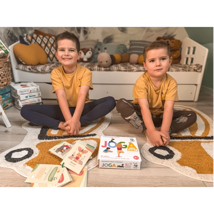 Chłopcy ćwiczący jogę na dywanie z grą edukacyjną Joga dla dzieci