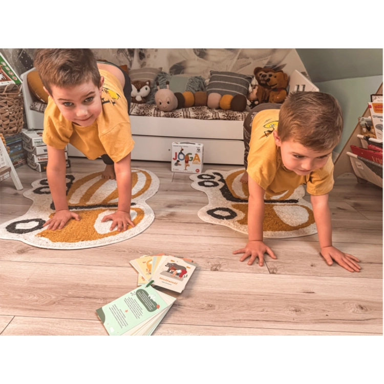 Dzieci w pozycji deski podczas zabawy z zestawem Joga dla dzieci