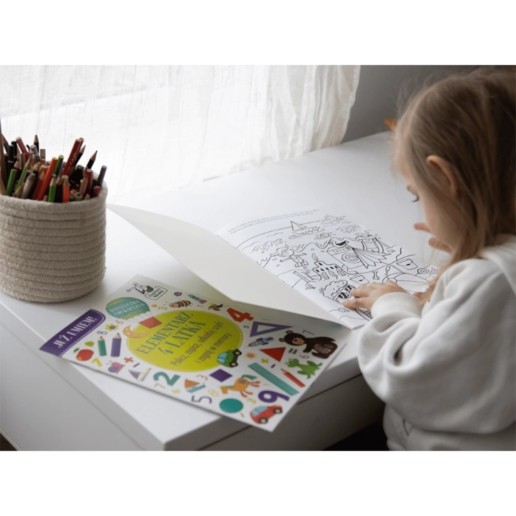 Dziewczynka koloruje ilustrację z zestawu edukacyjnego Kapitan Nauka dla 4-latków