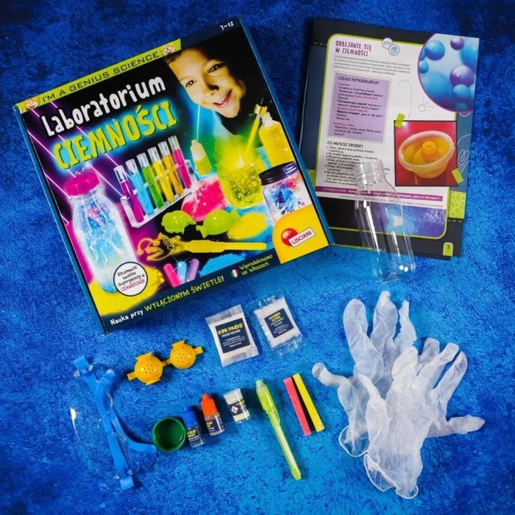 zawartość opakowania zestawu Mały Geniusz Laboratorium ciemności rozłożona na niebieskim tle