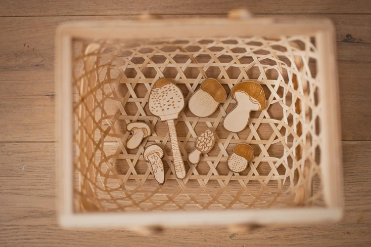 Dziewczynka układa puzzle edukacyjne z grzybami Sounds Wood na podłodze