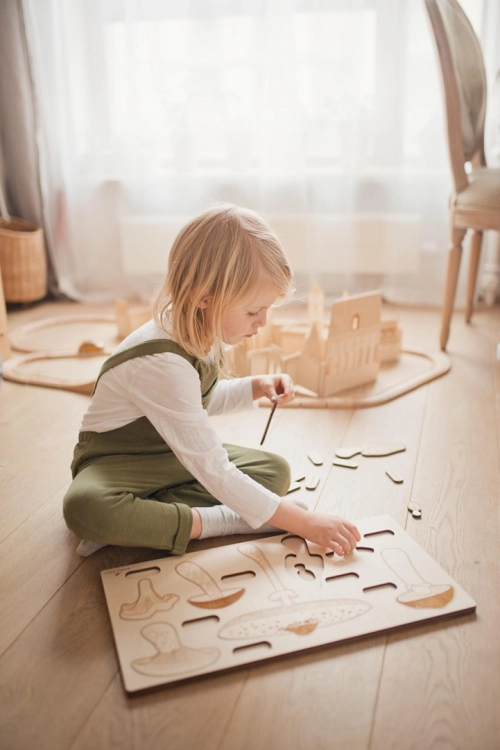 Dziecko bawi się drewnianymi puzzlami edukacyjnymi z grzybami Sounds Wood