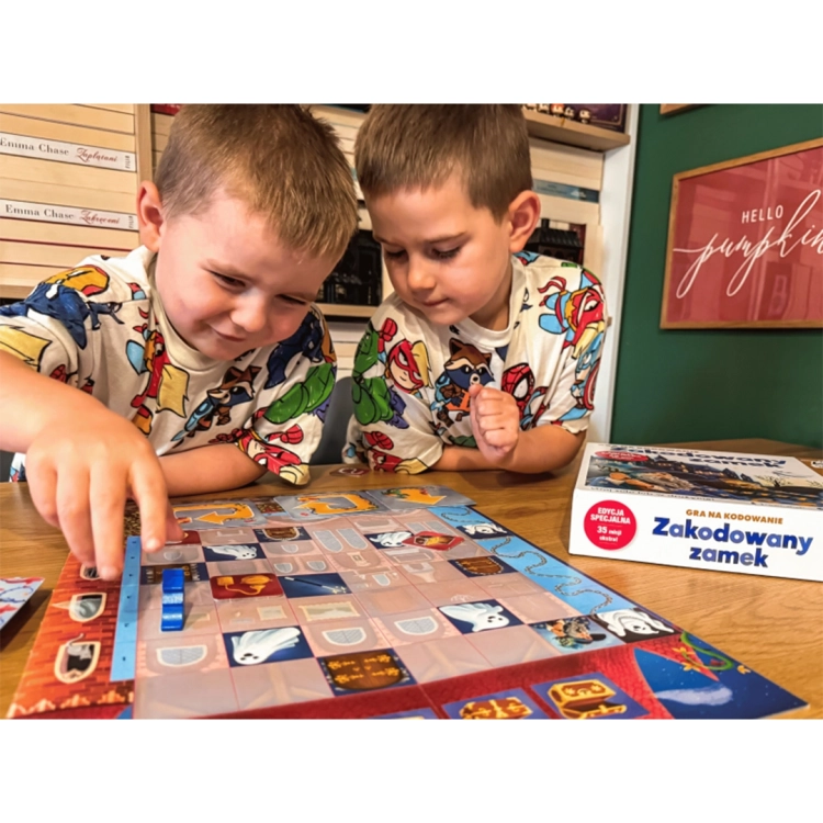 Dzieci grają w Zakodowany zamek, przesuwając pionek po planszy
