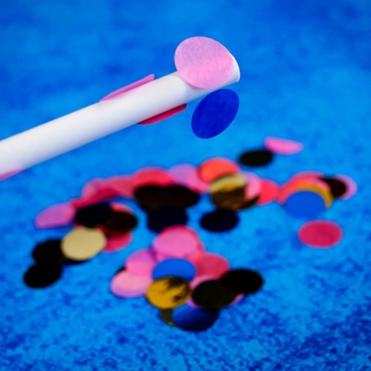 Kolorowe konfetti przyciągane przez naelektryzowaną rurkę