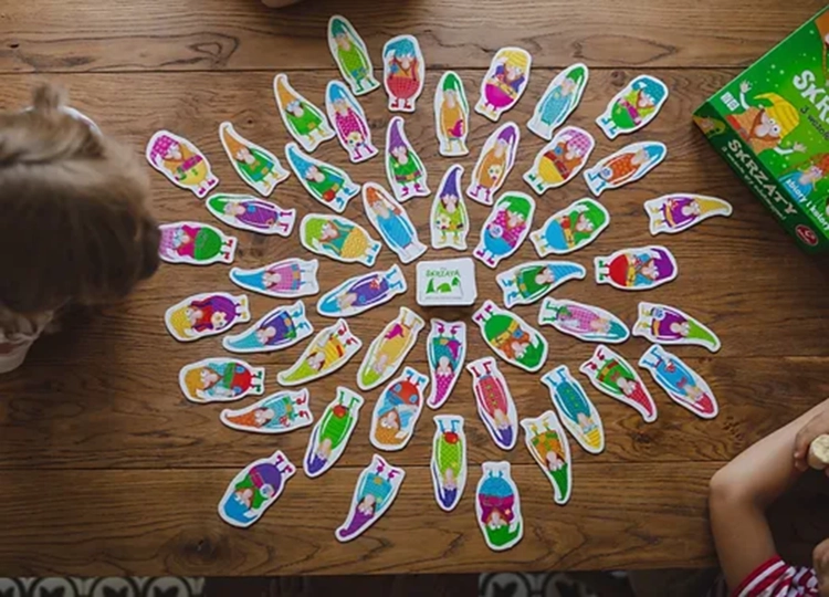 Karty z kolorowymi skrzatami rozłożone na stole – gra edukacyjna Skrzaty Kukuryku