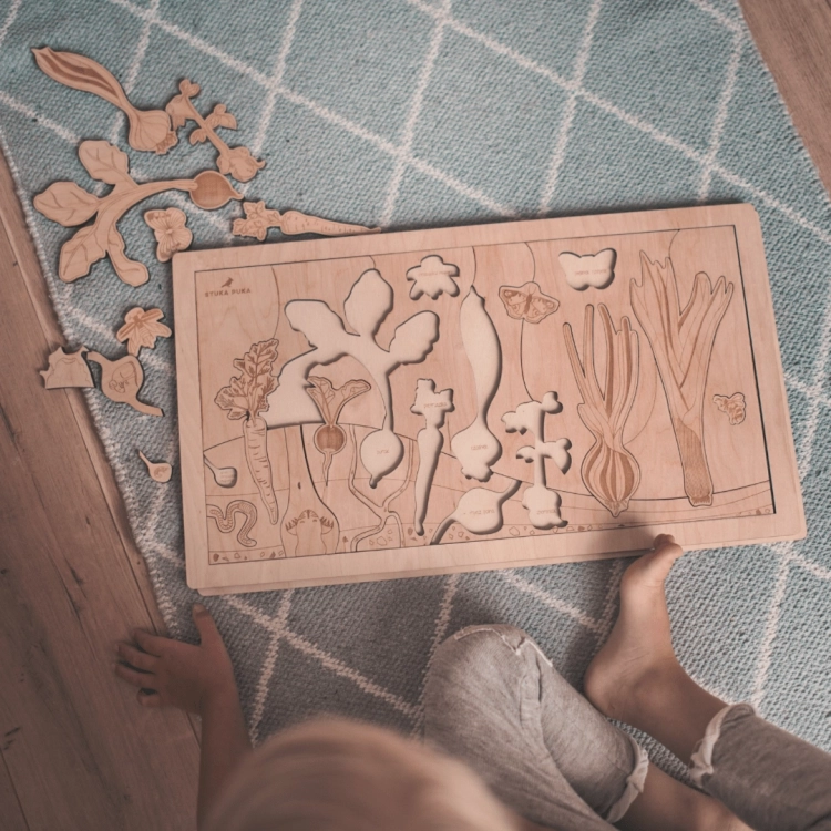 Dziecko siedzące przy puzzlach Warzywniak z rozsypanymi elementami