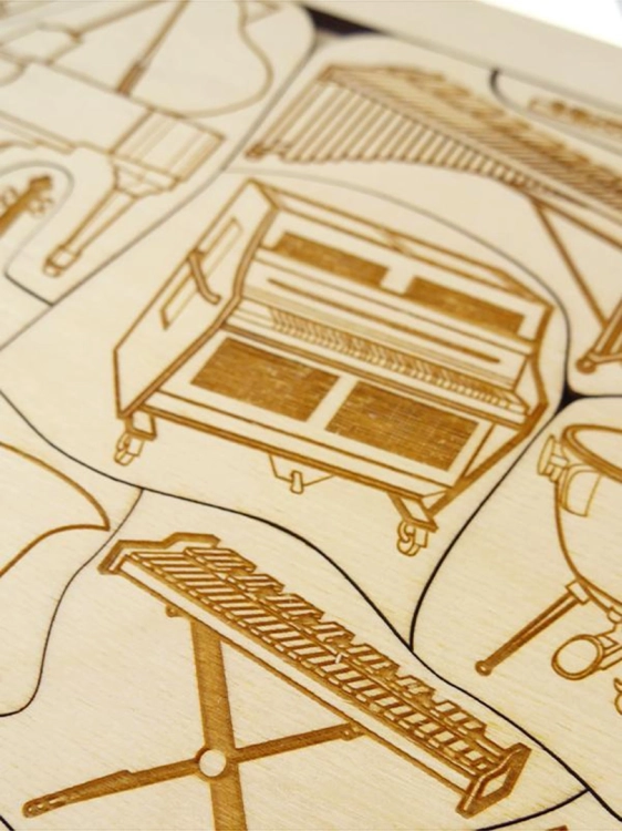 Detal drewnianych puzzli przedstawiający różne instrumenty muzyczne z bliska.