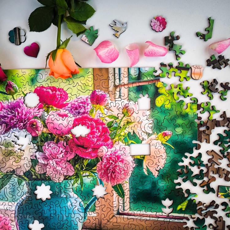 Puzzle z motywem kwiatów w wazonie – zbliżenie na brakujące elementy i kształty specjalne.