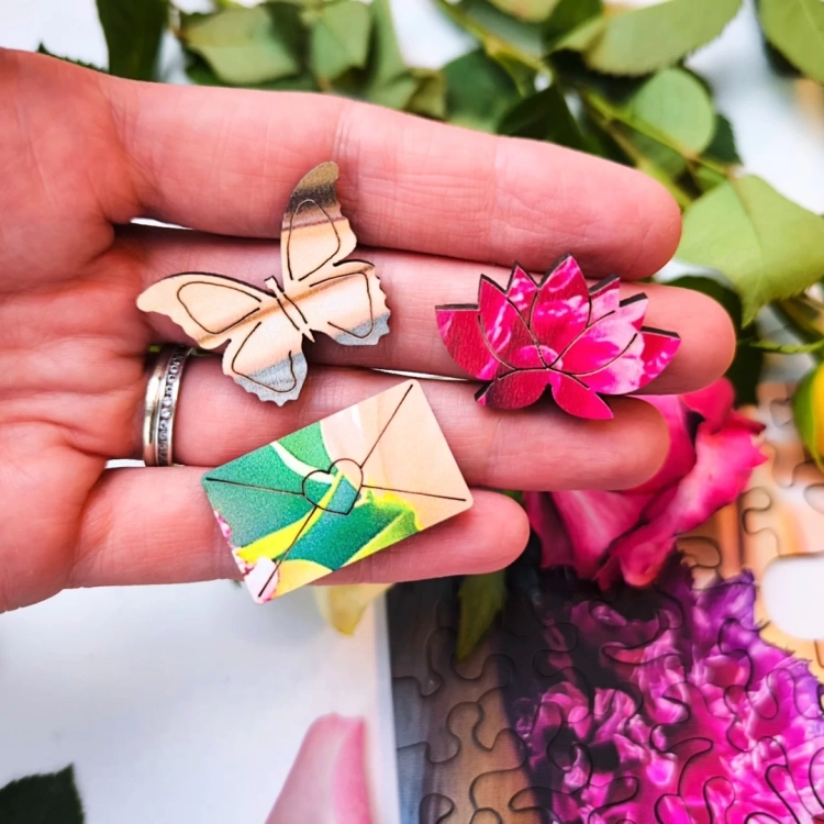 Zbliżenie na wyjątkowe elementy puzzli Milliwood – motyl, lotos i koperta.