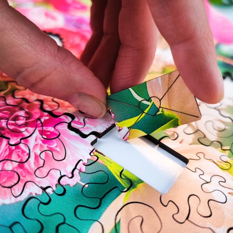 Ręka wkładająca kształtny element do drewnianych puzzli Milliwood.