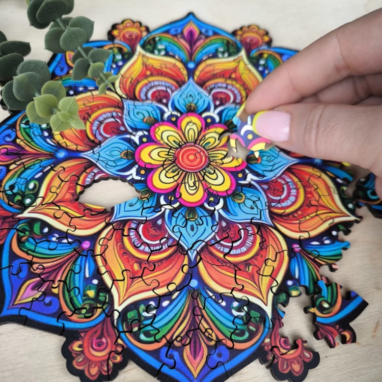 kobieca dłoń układająca element mandali, puzzle drewniane Mandala radości