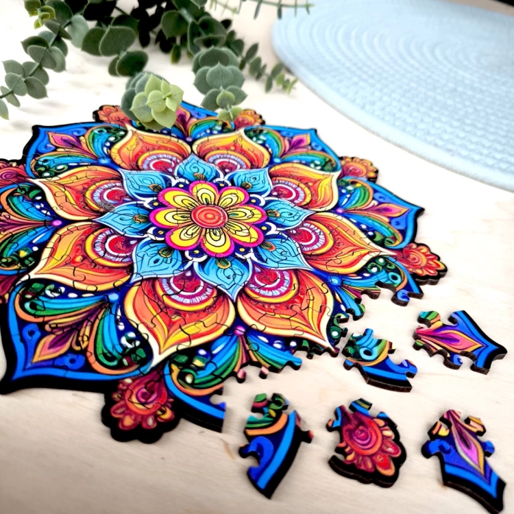 puzzle drewniane mandala na tle jasnej powierzchni i roślin doniczkowych