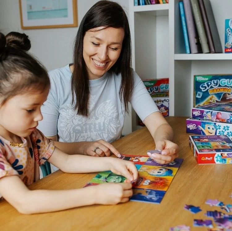 Kobieta i dziecko układają puzzle z filmu W głowie się nie mieści 2 firmy Trefl.