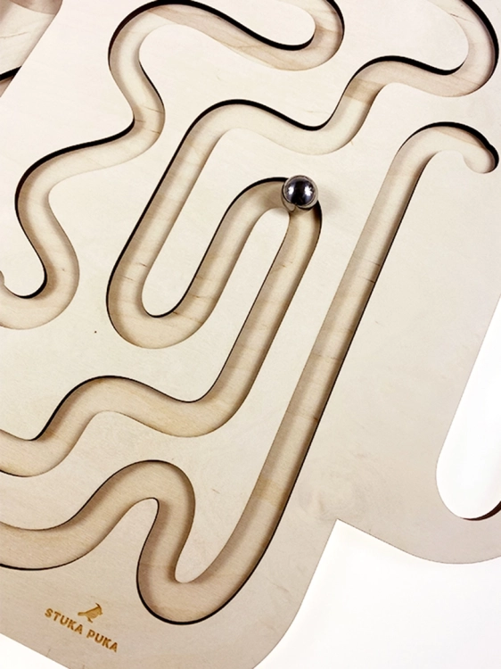 Szczegół drewnianego labiryntu Sounds Wood, metalowa kulka wewnątrz ścieżki.