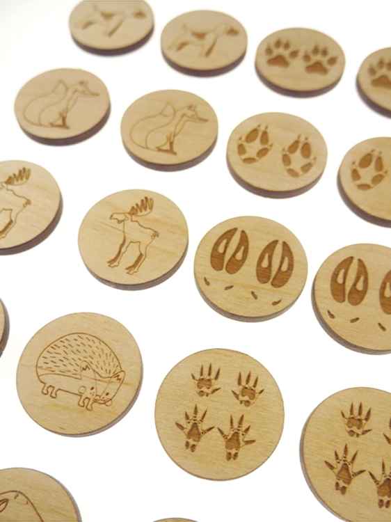 Zbliżenie na drewniane kółka z obrazkami zwierząt i śladów z gry memory Sounds Wood