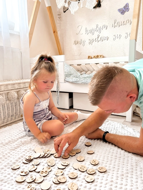 Dziecko i dorosły grają w drewnianą grę memory Jesteś na tropie; Sounds Wood