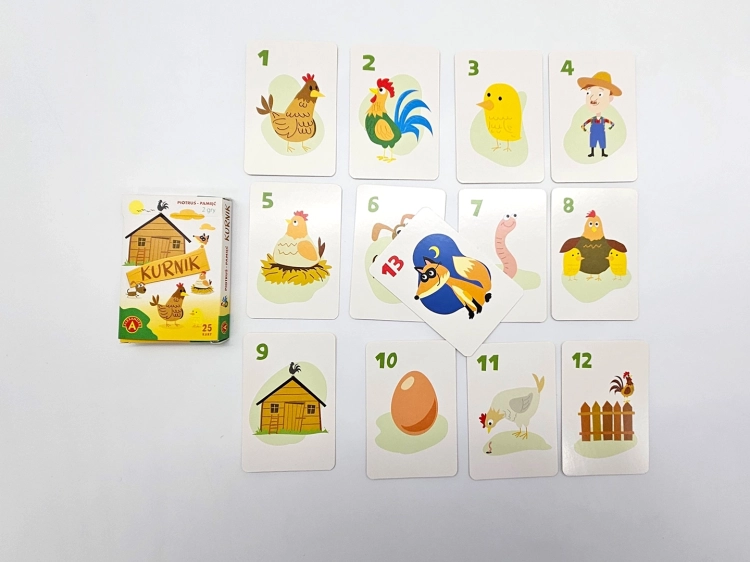 Komplet kart z gry Piotruś Pamięć Kurnik ułożonych w rzędach, z pudełkiem gry po lewej stronie.
