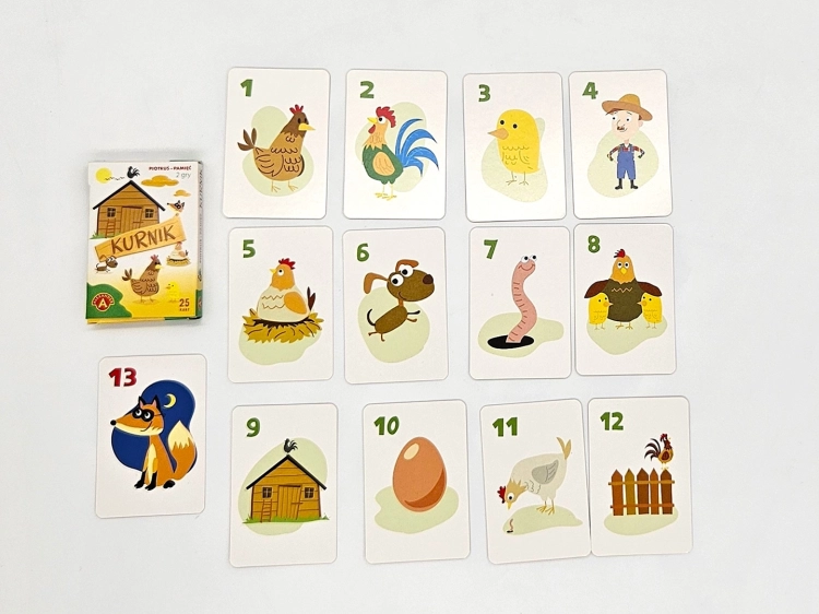 Wszystkie karty z gry Piotruś Pamięć Kurnik rozłożone w układzie, obok pudełka gry.