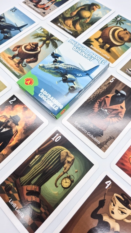 Pudełko gry Piotruś Brainrot Bombardiro Crocodillo leżące na rozłożonych kartach z surrealistycznymi ilustracjami.