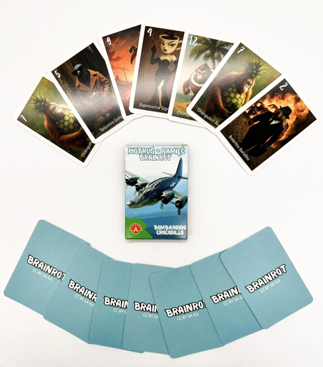 Pudełko gry Piotruś Brainrot Bombardiro Crocodillo otoczone rozłożonymi kartami z surrealistycznymi ilustracjami postaci.