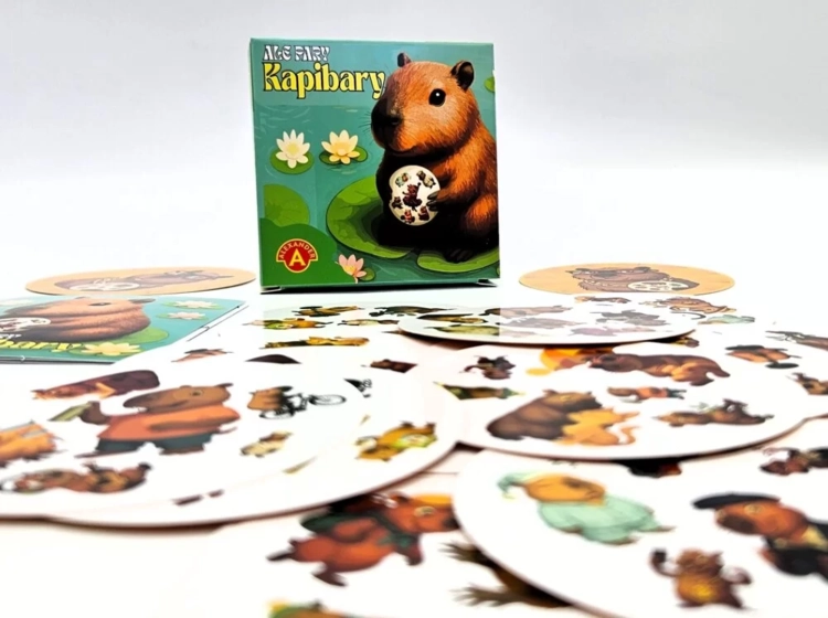 Pudełko gry "Ale Pary Kapibary" w otoczeniu rozłożonych okrągłych kart z kapibarami.