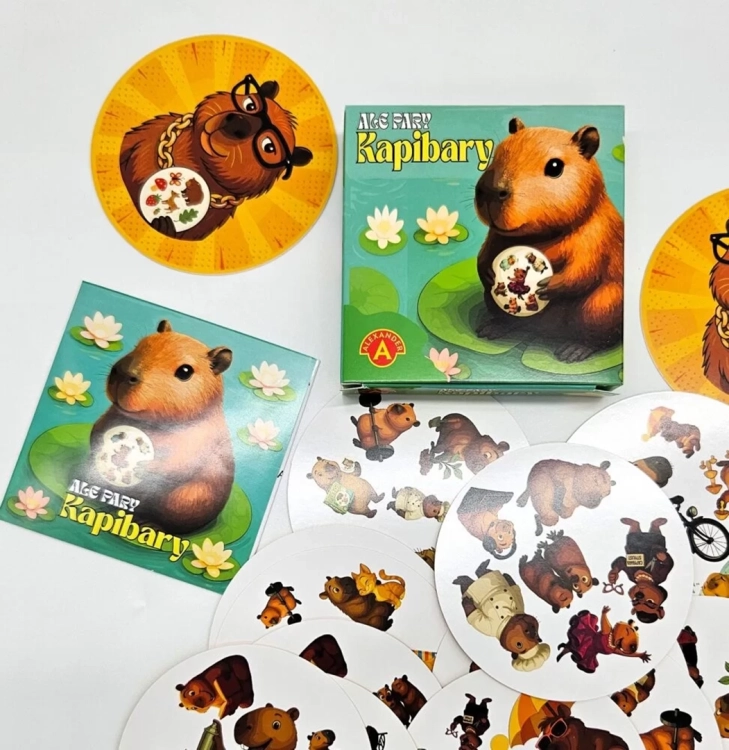 Pudełko gry "Ale Pary Kapibary" obok pojedynczej karty z kapibarą w okularach oraz rozłożonych okrągłych kart.