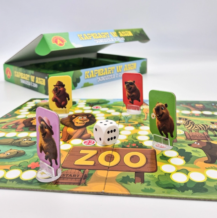 Plansza do gry "Kapibary w akcji – Ucieczka z zoo" z pionkami kapibar, kostką i otwartym pudełkiem w tle.
