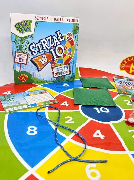Akcesoria do gry "Strzał w 10" marki Alexander, w tym woreczki z piaskiem, klepsydra, plansza i pudełko.