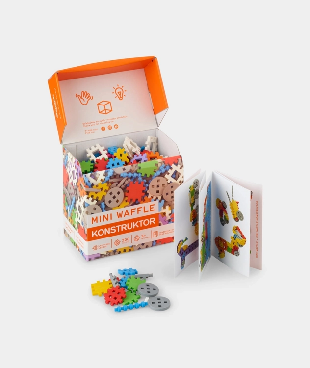 Otwarte pudełko klocków Marioinex Mini Waffle Constructor, widoczna instrukcja i kolorowe elementy.