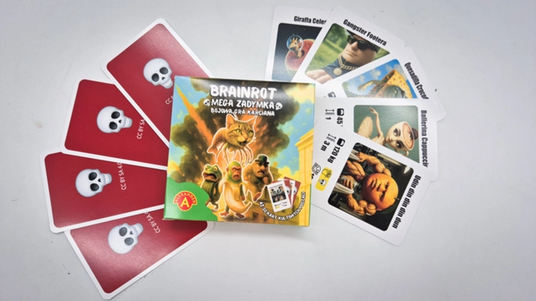 Karty z gry Brainrot Mega Zadymka rozłożone wokół opakowania, widoczne postaci i rewerse.