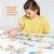 Dziewczynka układa długie puzzle CzuCzu Co robi weterynarz? na białym stole.