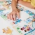 Zbliżenie na dłoń dziecka układającą element puzzli CzuCzu, scena z weterynarzem.