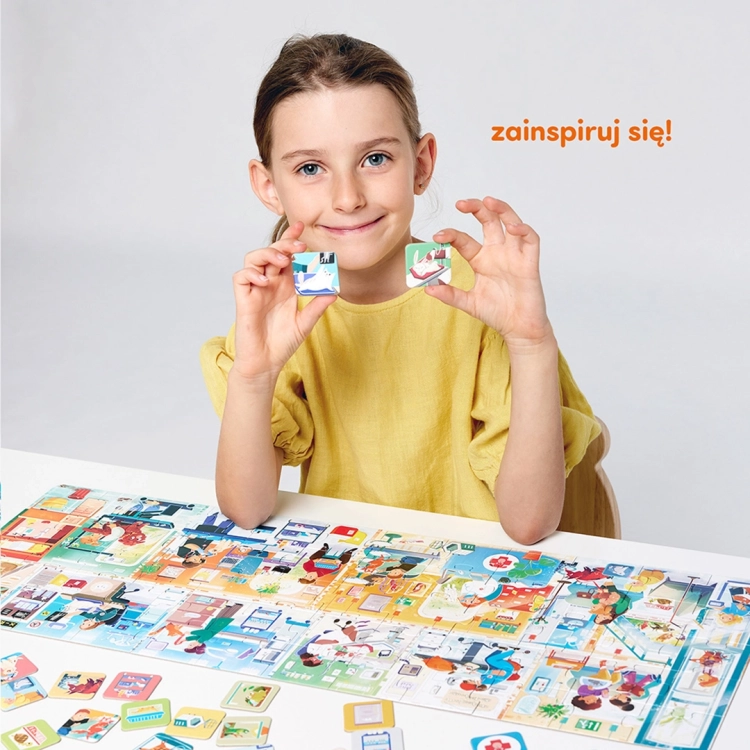 Uśmiechnięta dziewczynka trzyma w dłoniach dwa elementy małych obrazków do puzzli CzuCzu.