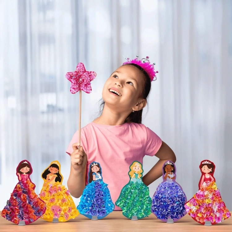 Dziewczynka trzyma różdżkę i uśmiecha się obok sześciu piankowych księżniczek Skillmatics Poke In Art.
