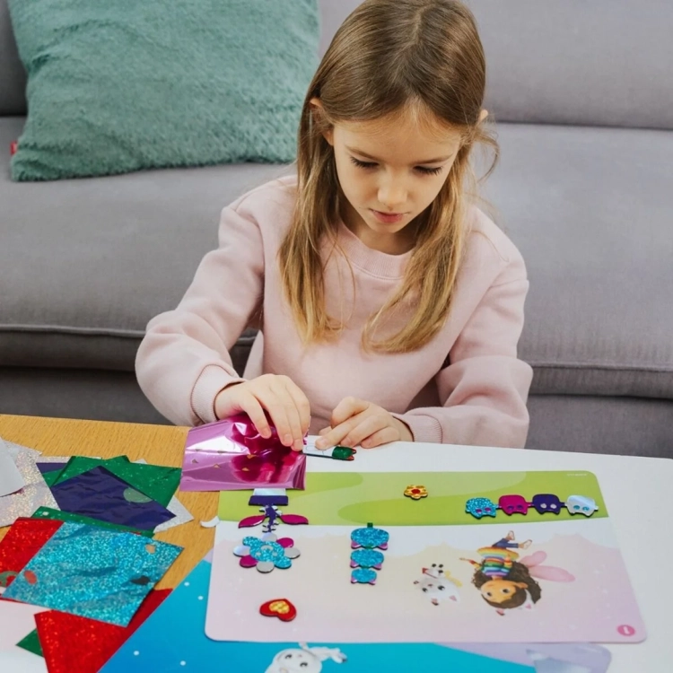 Dziewczynka używa folii w zestawie kreatywnym Skillmatics Foil Fun Koci Domek Gabby.